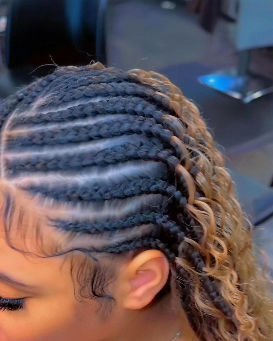 Cornrows gathered into a honey blonde curly ponytail, side profile