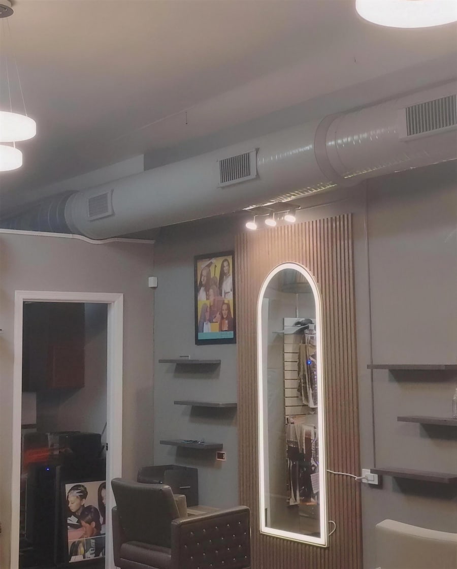 Styling station with an arched backlit mirror and fluted wall panelling